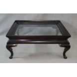 A Chinese style black lacquered and gilt coffee table with inset bevelled plate top on cabriole