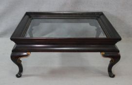 A Chinese style black lacquered and gilt coffee table with inset bevelled plate top on cabriole