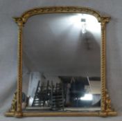 A 19th century carved gilt wood overmantel mirror with beaded arched pediment above original plate