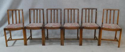 A set of six mid century oak slat back dining chairs on square chamfered supports. H.79cm