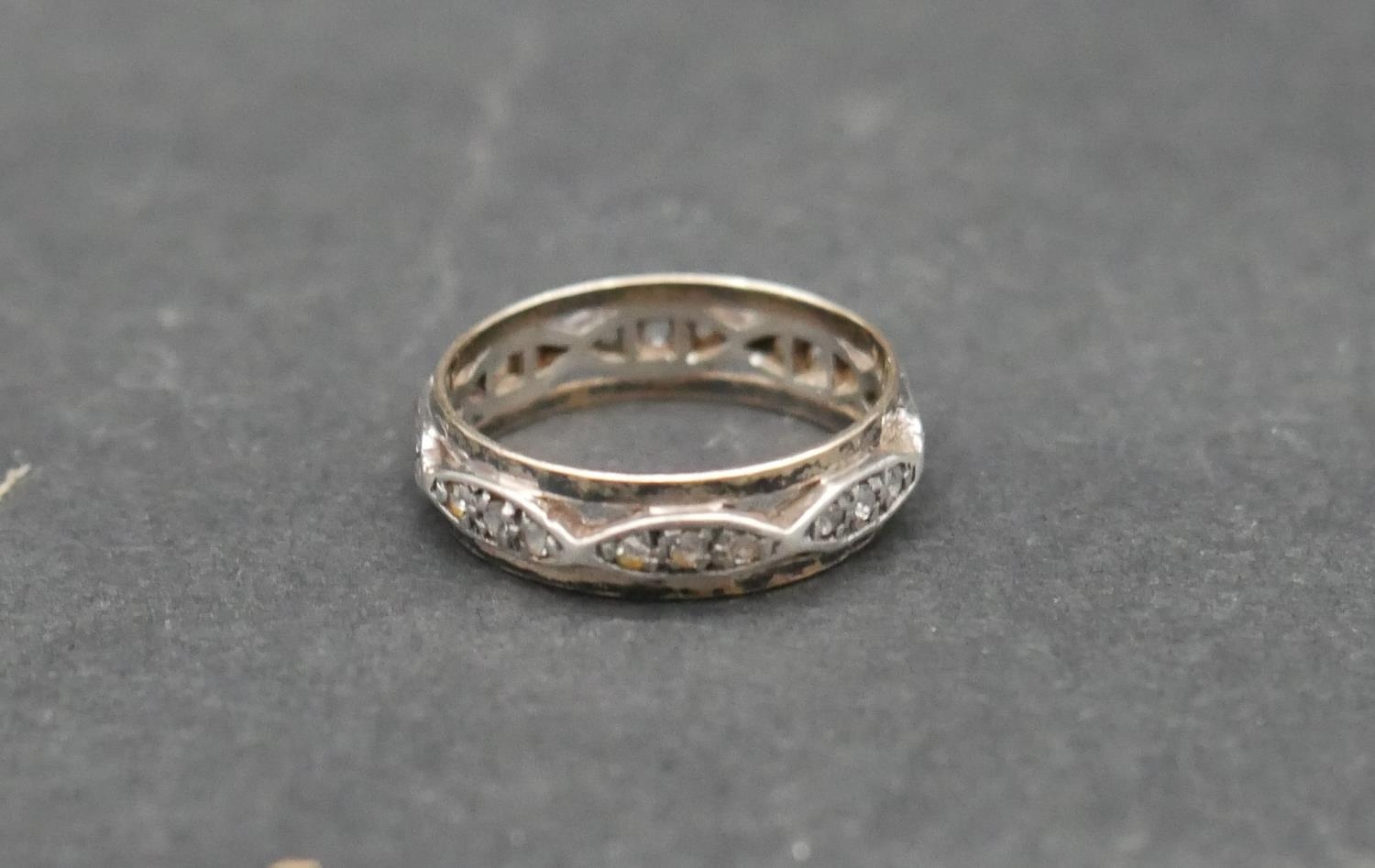An antique white metal and yellow metal eternity band set with hand cut white stones. With shaped