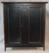 A Chinese lacquered wardrobe fitted for hanging space with faux bamboo frame and supports. H.175 W.