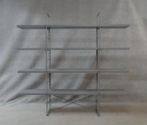 A contemporary adjustable metal framed shelving unit with laminated plywood shelves. H.158.5 W.170