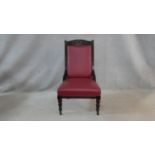 A Victorian carved frame nursing chair in faux leather upholstery on turned tapering supports. H.