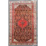An antique Persian Malayer carpet with central hooked pole medallion on a stylised floral field