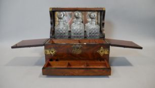 A 19th century burr walnut and brass bound three bottle tantalus with cut glass decanters and