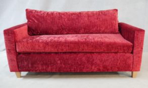 A contemporary two seater sofa in crushed velour upholstery on tapering block supports. H.75 L.178