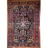 A Persian Hamadan rug with central floral medallion on midnight ground within stylised floral