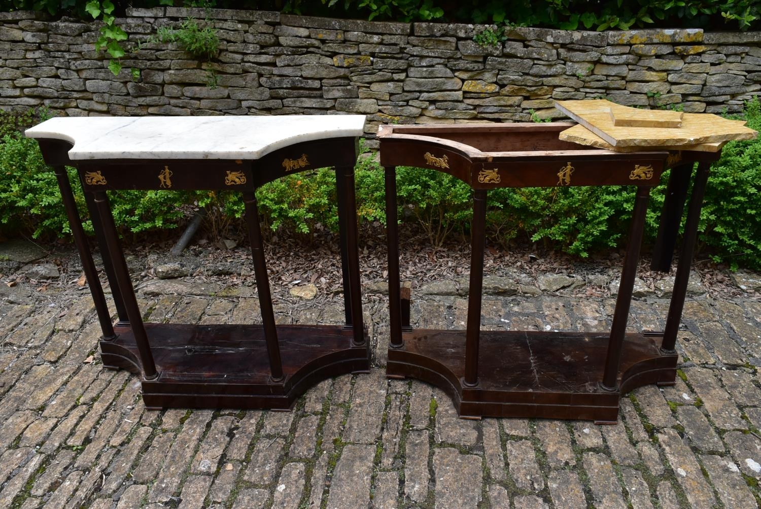 A pair of French Empire mahogany console tables with marble tops and classical motif ormolu mounts