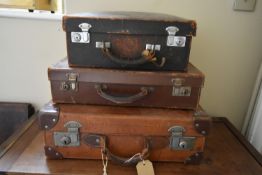 A small leather case fitted with filing drawers, a vintage leather suitcase and another vintage