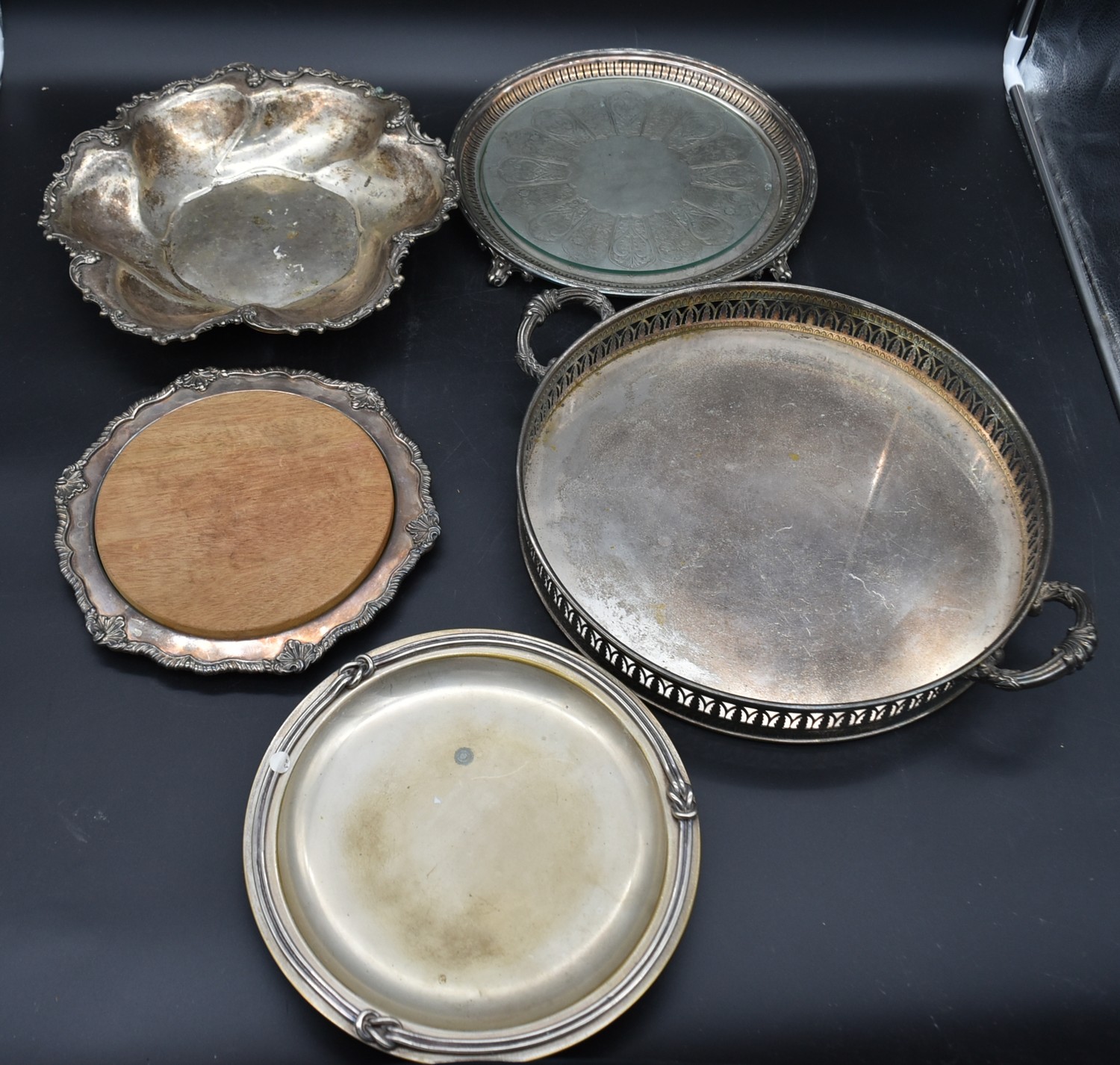 A silver plated twin handled galleried tray, a silver plated bread board and three other silver