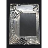 An Art Nouveau style velvet backed silver easel photo frame with stylised lady in flowing dress