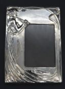 An Art Nouveau style velvet backed silver easel photo frame with stylised lady in flowing dress