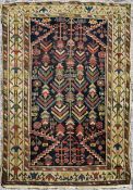 A Persian rug with repeating stylised motifs on a midnight ground within geometric borders. L.150