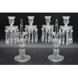 A pair of clear glass twin branch candelabras with crystal drops on spiral twist base. H.34cm W.24cm