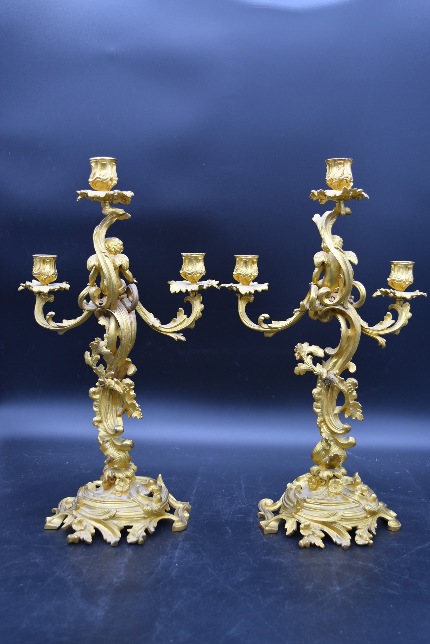 A pair of gilt metal three branch table candelabras with cherub surmounts raised on Rococo scrolling - Image 5 of 5