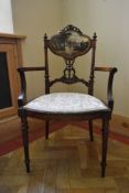 A late 19th century carved walnut salon armchair with hand painted back panel on fluted tapering