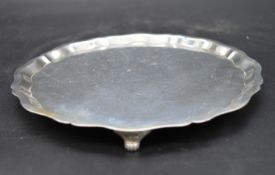 A silver card tray with shaped rim on scrolling feet, hallmarked EV for Viner's Ltd, Sheffield 1935.