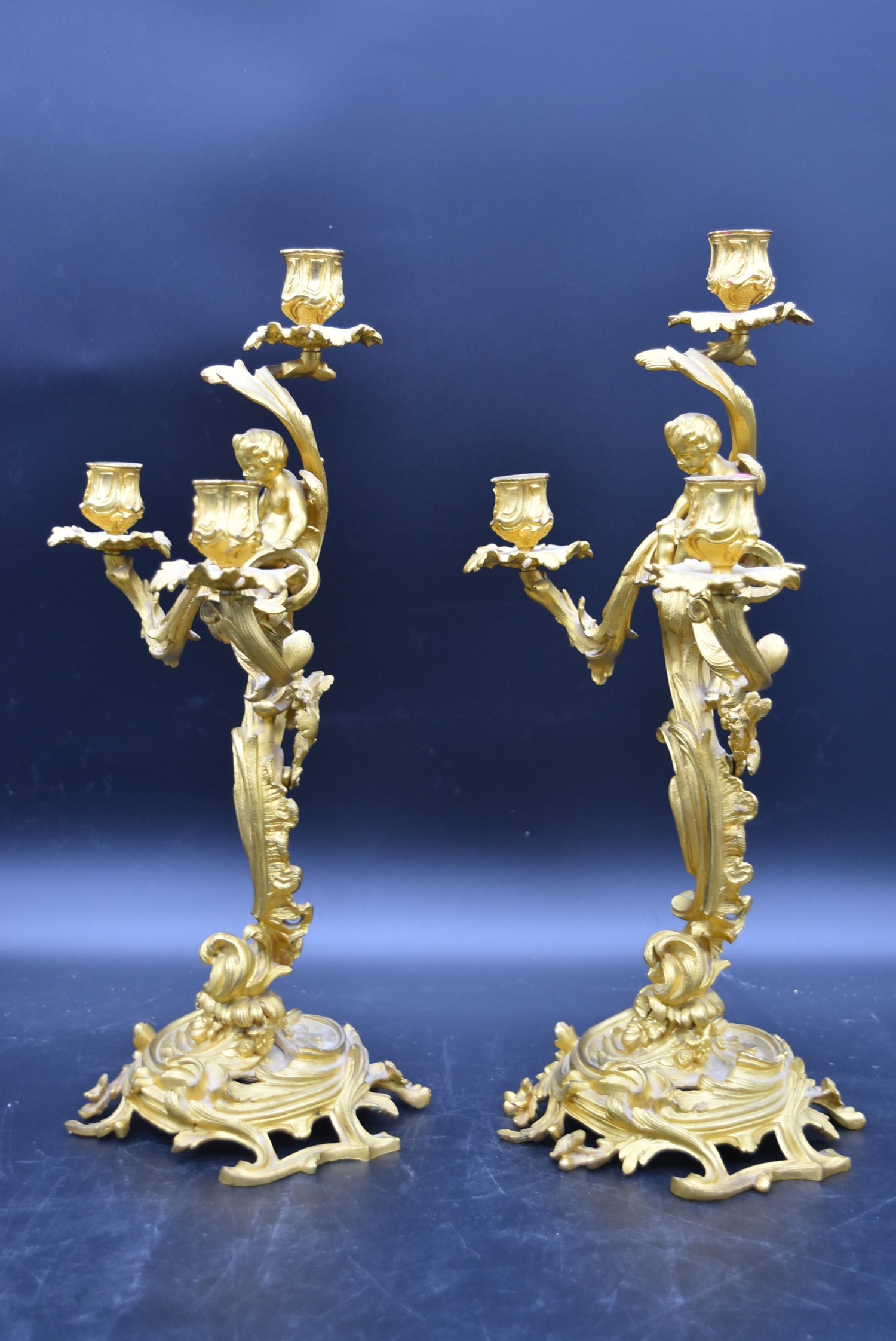 A pair of gilt metal three branch table candelabras with cherub surmounts raised on Rococo scrolling - Image 3 of 5