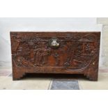 A Chinese camphor coffer with all over relief carved decoration of figures, birds and foliage in