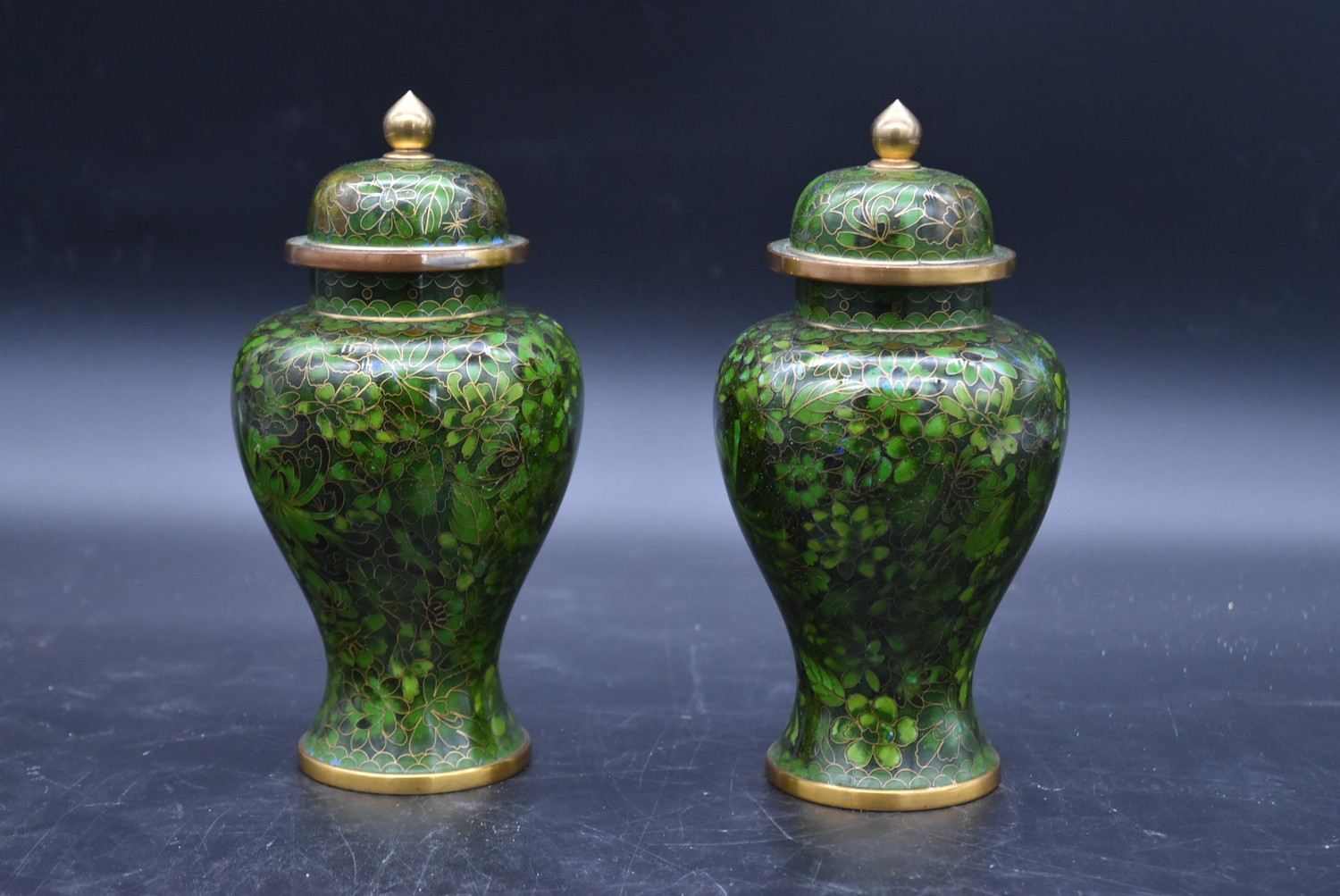 A pair of Chinese cloisonné lidded vases with all over floral enamel decoration. H.23cm