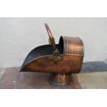 A 19th century copper helmet shaped coal scuttle with brass swing handle. H.41cm