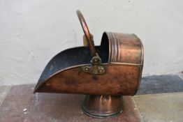 A 19th century copper helmet shaped coal scuttle with brass swing handle. H.41cm