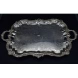 A silver plated twin handled tray with shaped Rococo scrolling and shell motif rim sitting on scroll
