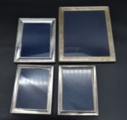 A collection of four silver easel picture frames each bearing an English hallmark. H.30cm W.25cm (