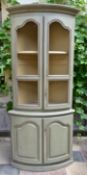 A French Provincial style painted corner cabinet with upper glazed section above panelled doors on