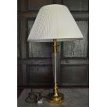 A glass and brass table lamp on stepped base. H.78cm W.15cm