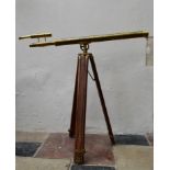 A brass telescope on adjustable tripod stand. H.95 W.100cm