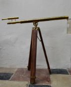 A brass telescope on adjustable tripod stand. H.95 W.100cm