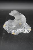 A Lalique frosted glass sea lion figure sitting on a rock. With original label and box, signed