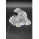 A Lalique frosted glass sea lion figure sitting on a rock. With original label and box, signed