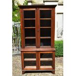 A late 19th century twin section walnut bookcase with glazed panel doors enclosing bookshelves to