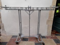 An unusual folding and mobile metal framed coat hanging rack on casters. H.160 W.35cm (closed)