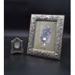 A dressing table clock in embossed English silver hallmarked case and a floral embossed