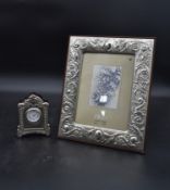 A dressing table clock in embossed English silver hallmarked case and a floral embossed