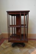 An Edwardian mahogany and satinwood strung revolving bookcase on platform base. H.85 W.46cm