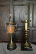 A brass table lamp in the shape of a Classical urn along with another brass table lamp and a