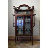 A late 19th century mahogany Art Nouveau display cabinet with mirrored upstand above a pair of