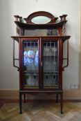 A late 19th century mahogany Art Nouveau display cabinet with mirrored upstand above a pair of