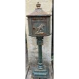 A vintage style cast iron post or letter box on pedestal base with relief horse and jockey design.