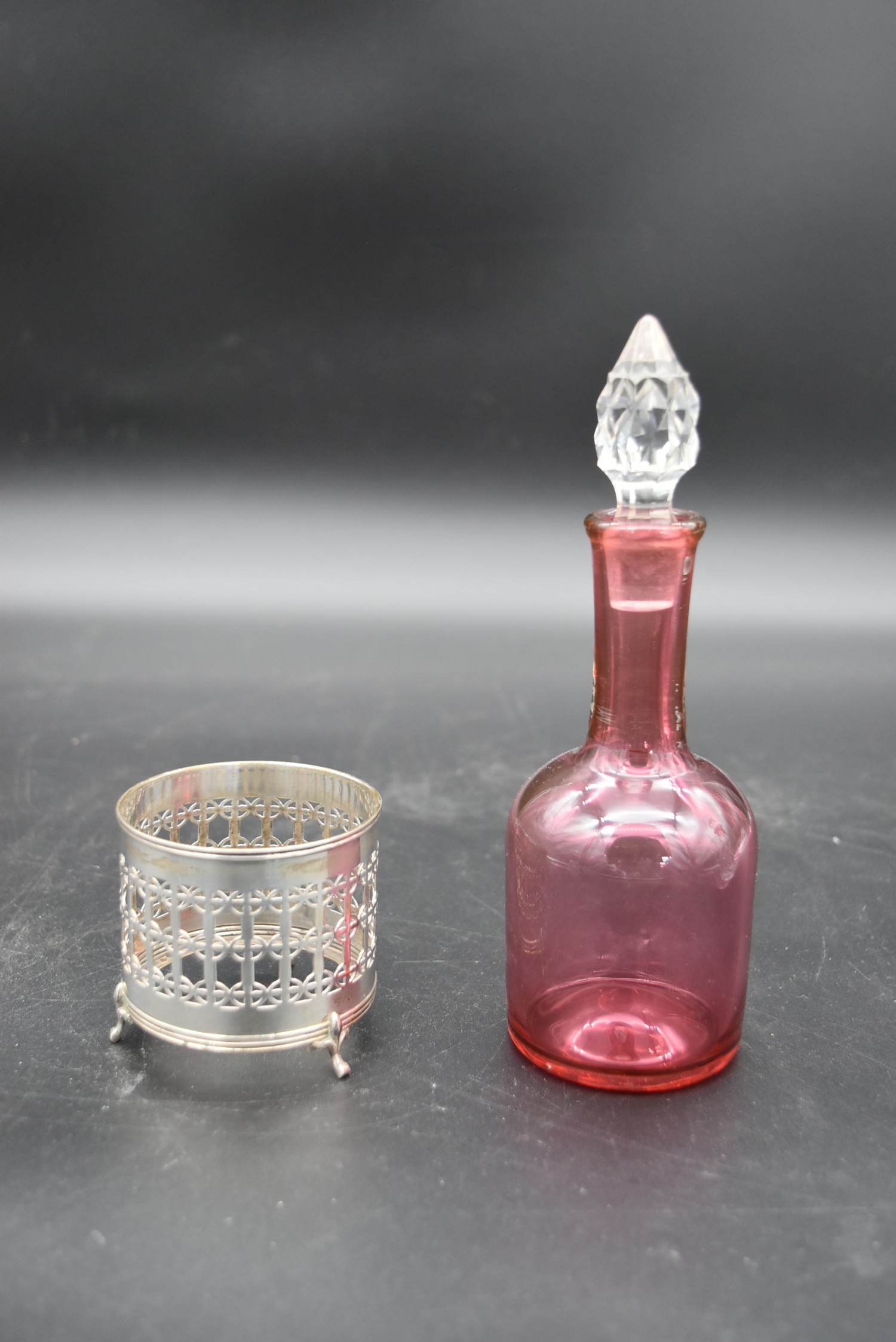 A cut cranberry glass bottle and stopper in a silver pierced stand hallmarked Birmingham 1923 - Image 5 of 6