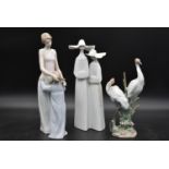 Three Lladro figure groups; mother and child, nuns and cranes amongst the bulrushes. H.37cm (