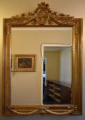 A 19th century style gilt pier mirror with bevelled plate in a floral, husk and swag designed frame.