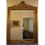 A 19th century style gilt pier mirror with bevelled plate in a floral, husk and swag designed frame.