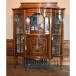 An Edwardian mahogany mirror backed display cabinet with a profuse swag and ribbon inlaid central