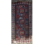 A Shirvan rug with triple star medallions on a madder ground within flowerhead multi borders. L.